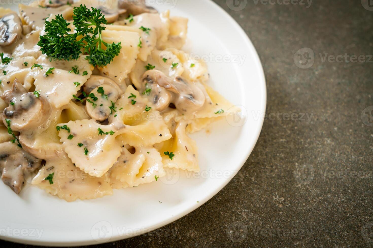 macarrão farfalle com molho de creme de cogumelos branco foto