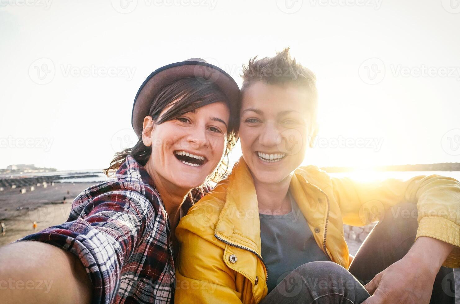 feliz gay casal levando selfie em a de praia às pôr do sol - jovem lésbicas tendo Diversão namoro primeiro Tempo - lgbt, homossexualidade amor e relação estilo de vida conceito foto