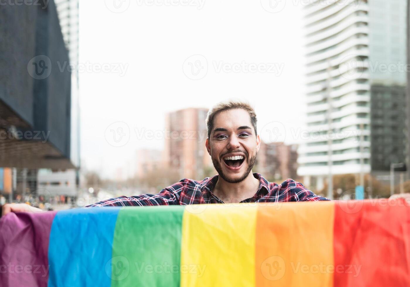 feliz gay homem tendo Diversão segurando arco Iris bandeira símbolo do lgbtq comunidade foto