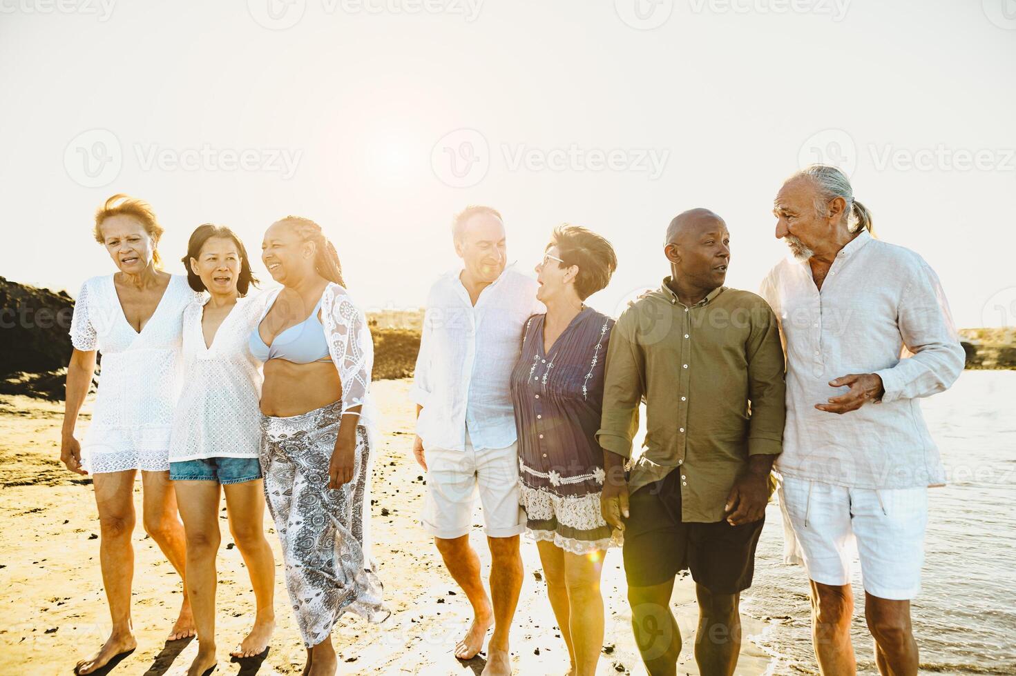 feliz multirracial Senior amigos tendo Diversão caminhando em a de praia durante verão feriados - diverso idosos pessoas desfrutando Férias foto