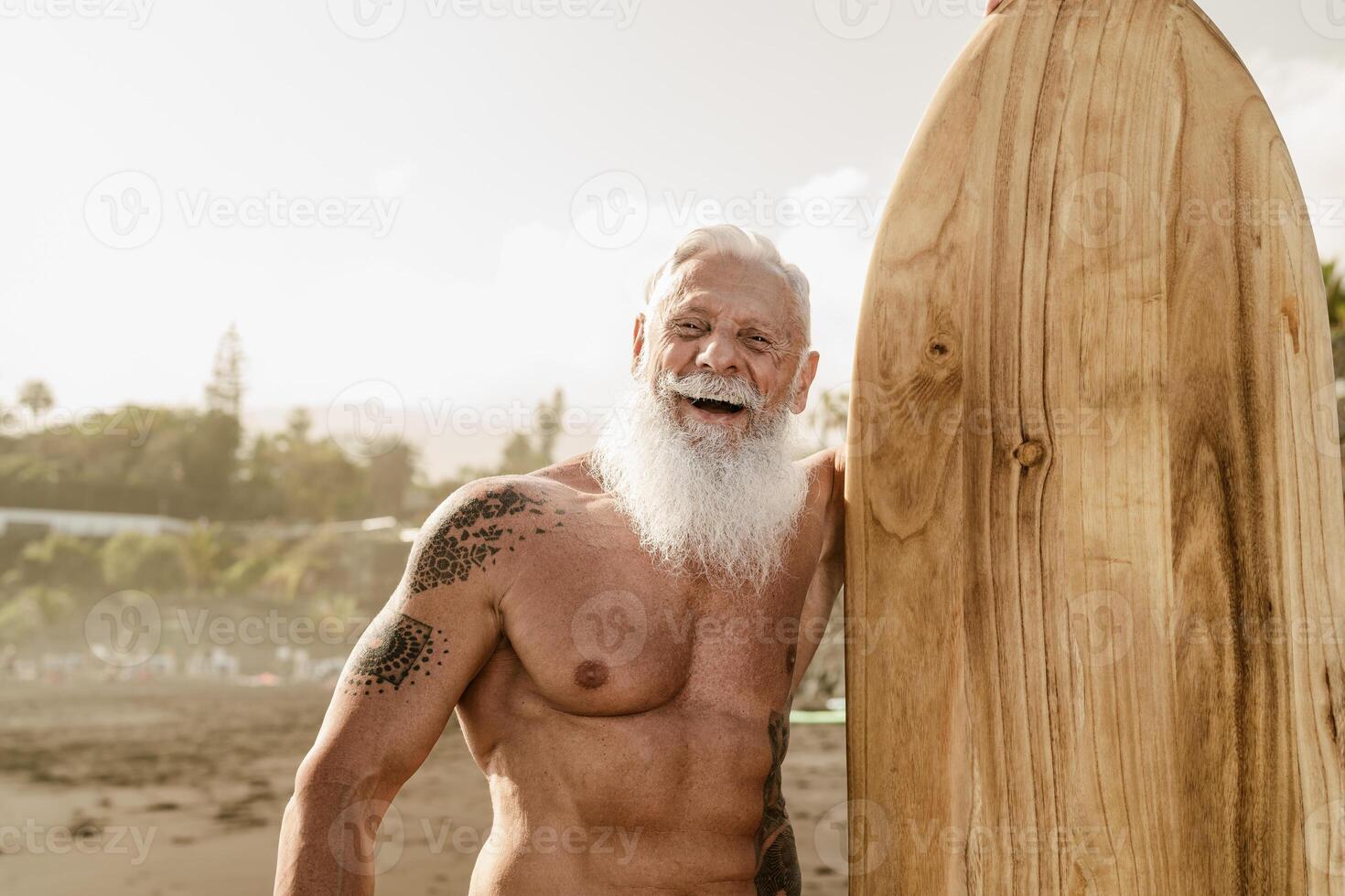 Senior em forma homem tendo Diversão surfar em tropical de praia - idosos saudável pessoas estilo de vida e extremo esporte conceito foto