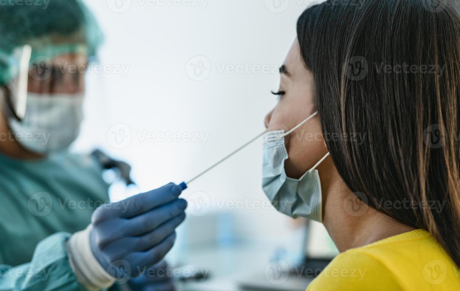 médico trabalhador vestindo pessoal protetora equipamento fazendo corona vírus cotonete em fêmea paciente - covid19 teste e saúde Cuidado conceito foto