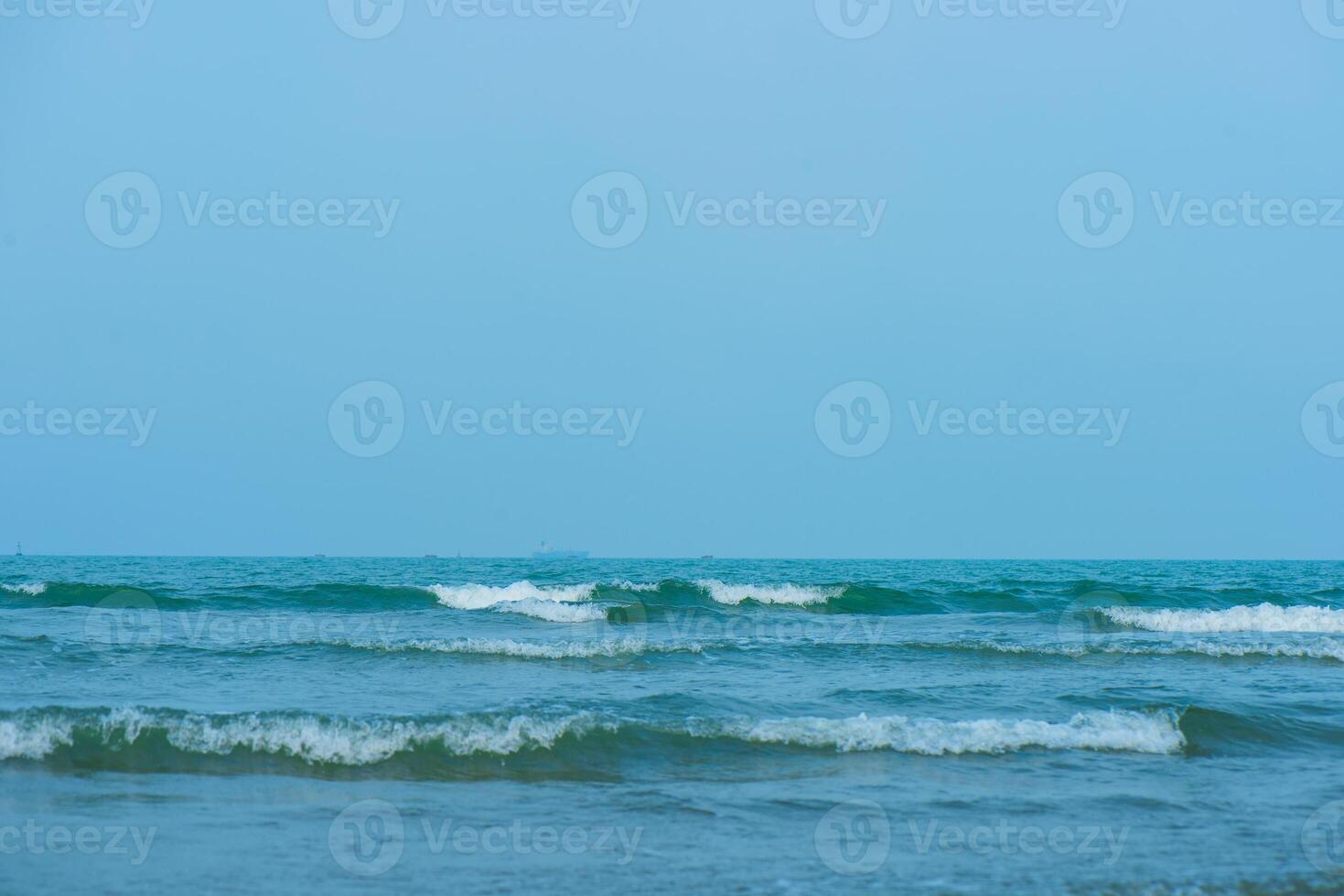 ondas em a de praia. azul mar aceno. azul água superfície textura com ondulações, salpicos, e bolhas. abstrato verão bandeira fundo água ondas dentro luz solar com cópia de espaço Cosmético hidratante. foto