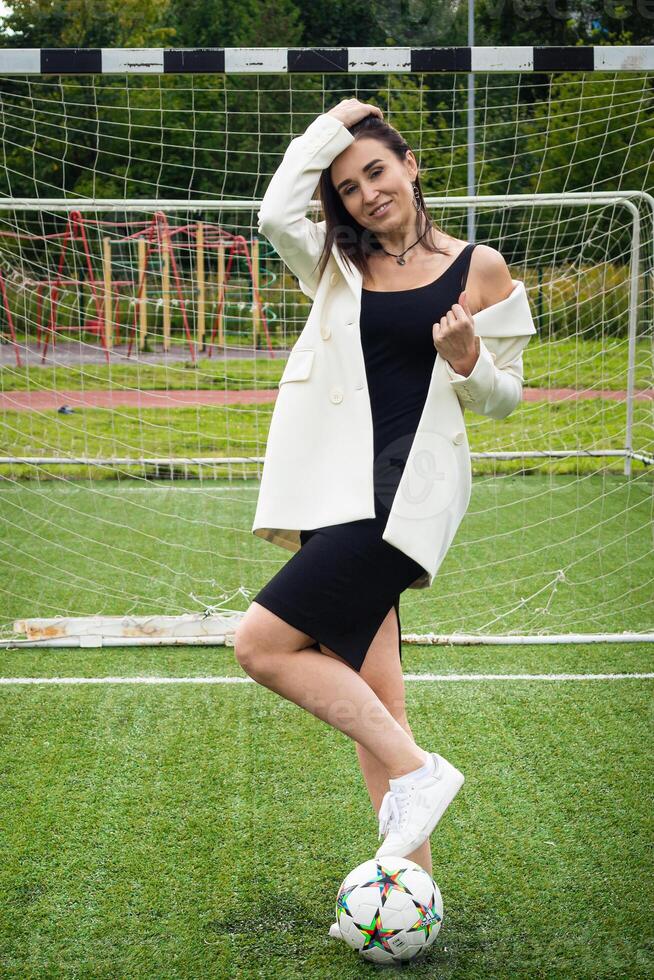 retrato do uma lindo mulher futebol jogador dentro uma rigoroso escritório terno. foto