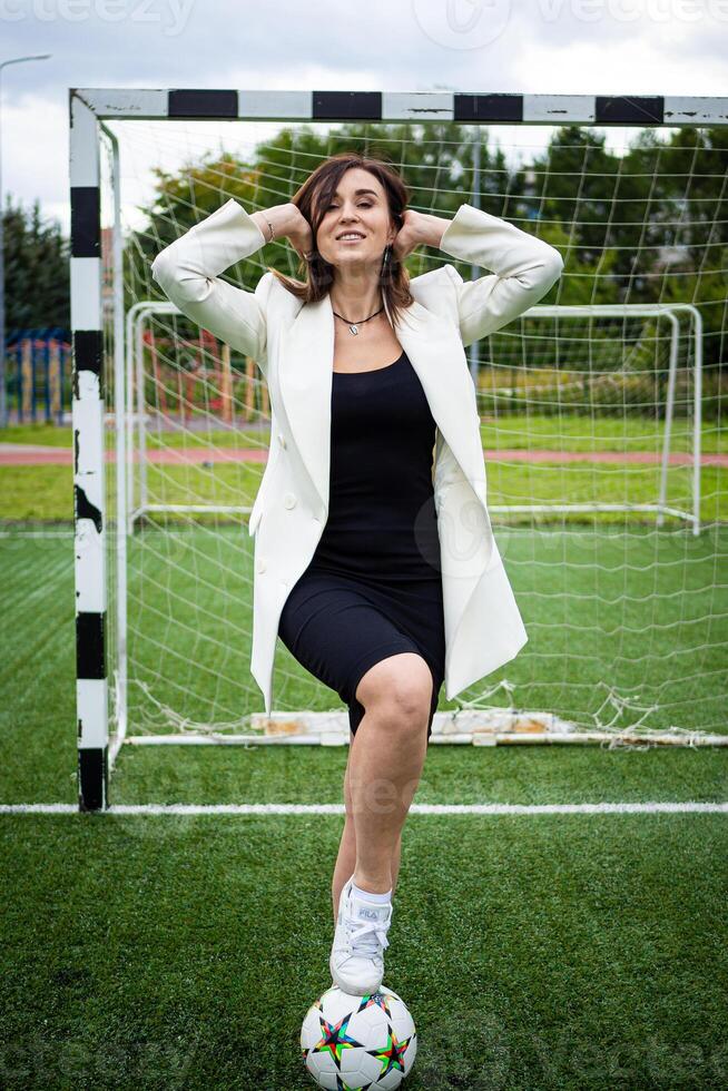 retrato do uma lindo mulher futebol jogador dentro uma rigoroso escritório terno. foto