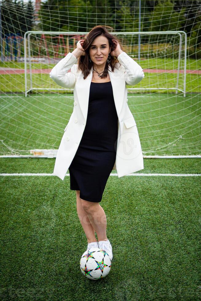 retrato do uma lindo mulher futebol jogador dentro uma rigoroso escritório terno. foto