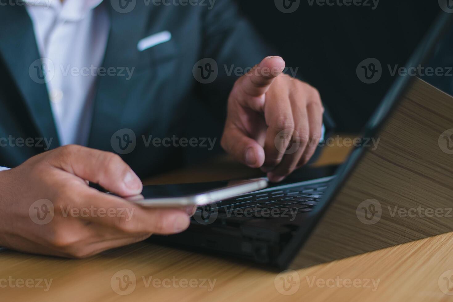 fechar-se do uma homem de negocios trabalhando com uma caderno computador e apontando dele mão dentro a escritório escrivaninha pensando sobre trabalhos e metas. foto