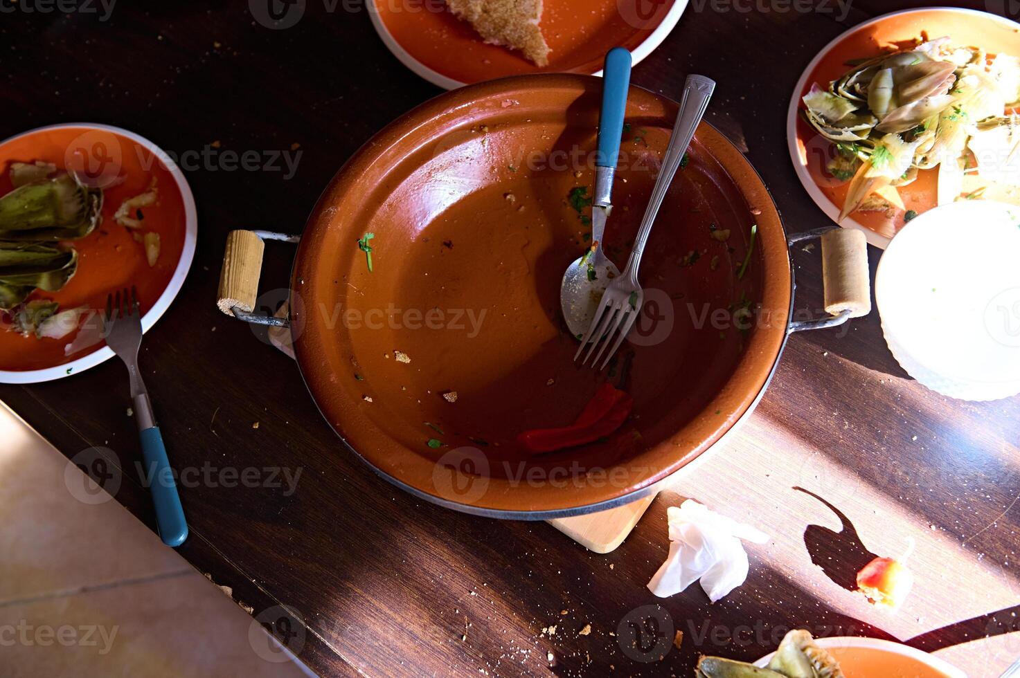 Visão a partir de acima do a esvaziar sujo tagine e pratos com a sobras do Comida depois de almoço ou jantar foto