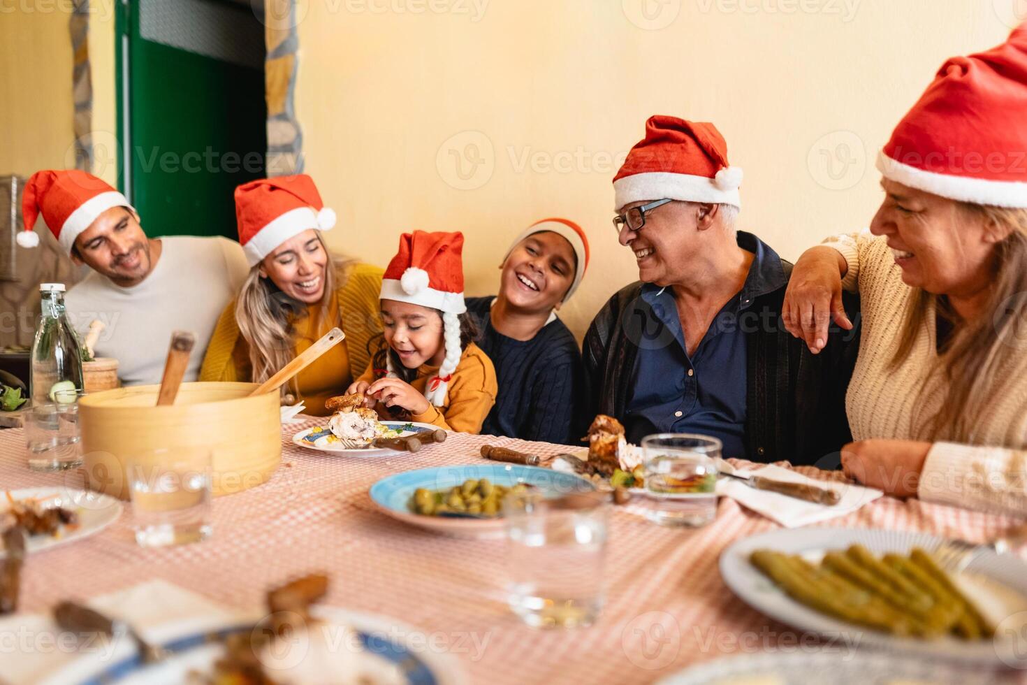 feliz latim família jantar juntos enquanto a comemorar Natal feriados às casa foto