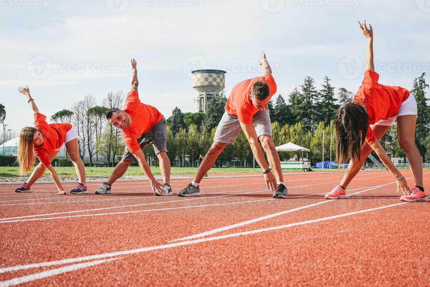 desportivo amigos alongamento pernas antes corrida - jovem corredores Treinamento juntos ao ar livre - conceito do saúde pessoas exercício para uma raça foto