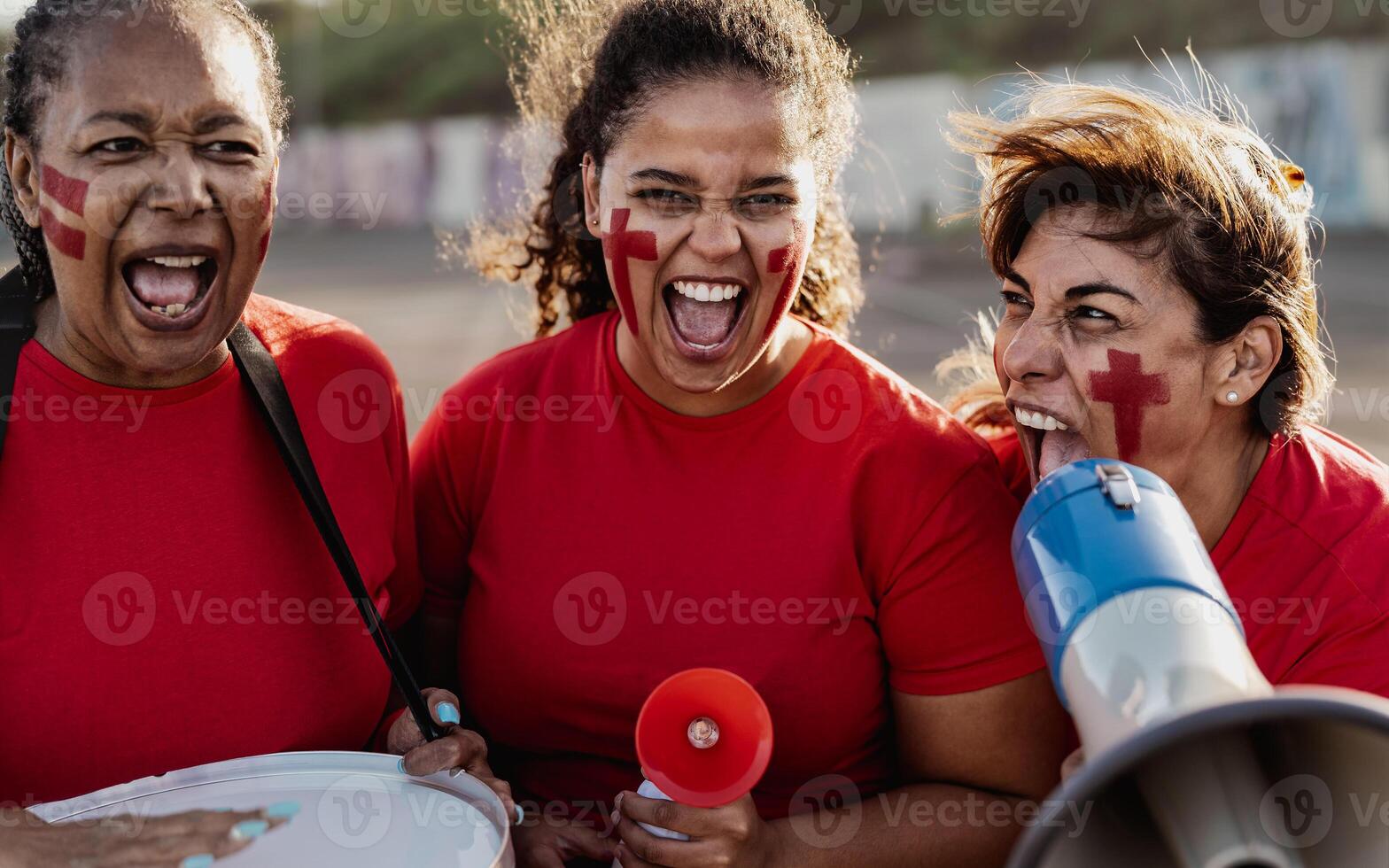 fêmea futebol fãs exultante enquanto assistindo uma futebol jogos às a estádio - mulheres com pintado face e megafone encorajando seus equipe - esporte entretenimento conceito foto