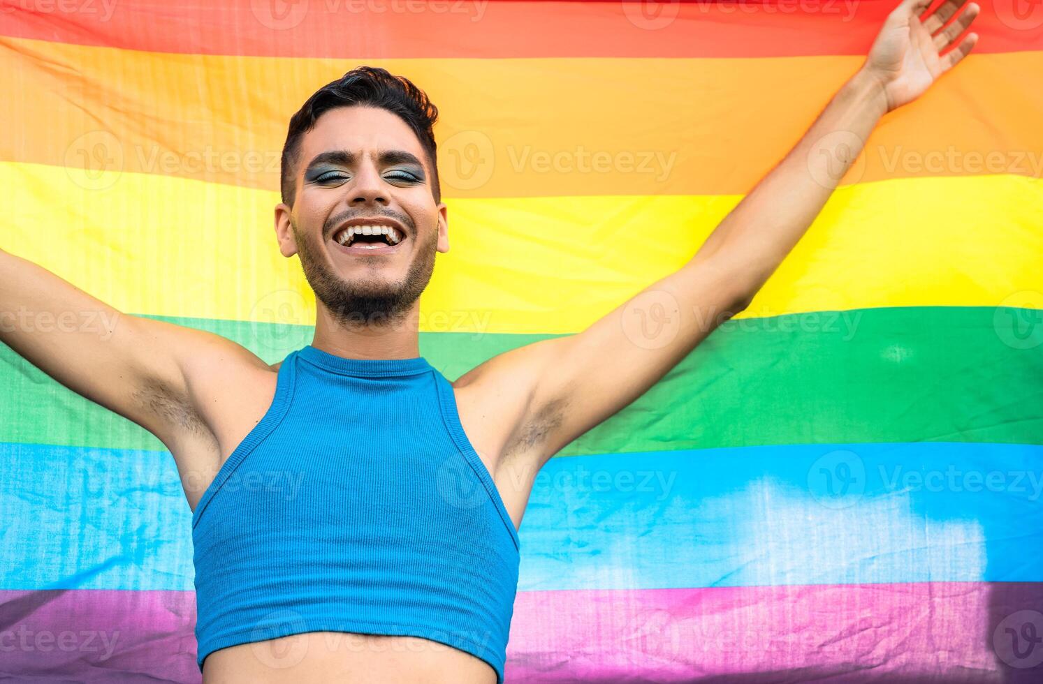 feliz homossexual homem a comemorar gay orgulho segurando arco Iris bandeira símbolo do lgbtq comunidade foto