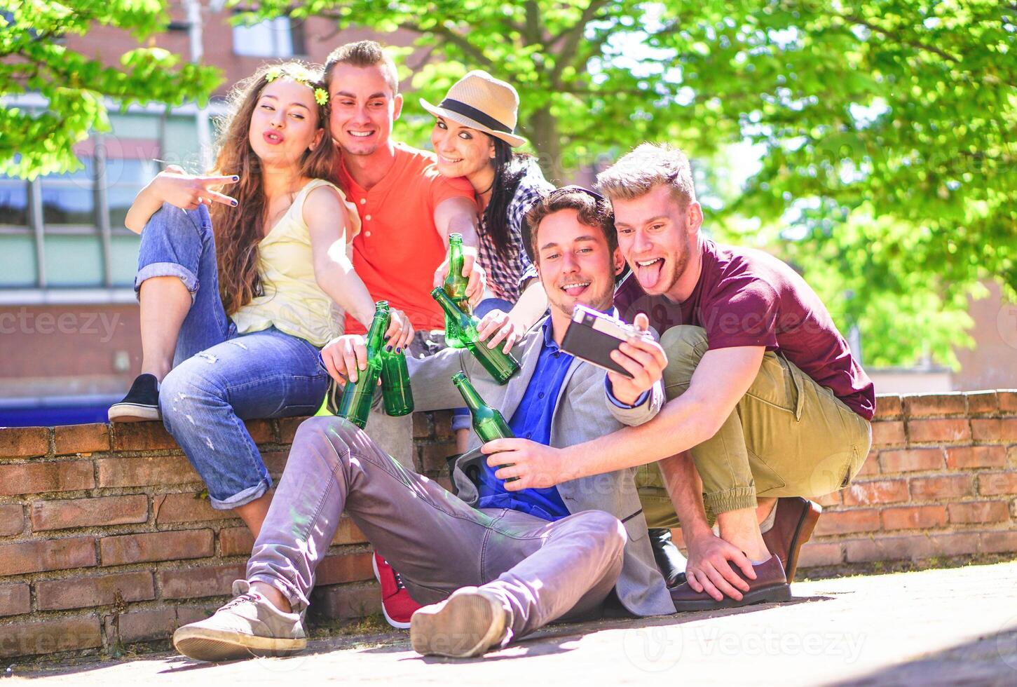 grupo do feliz amigos bebendo cervejas e levando selfie com uma vintage Câmera ao ar livre - jovem pessoas fazer fotos enquanto brindar e torcendo garrafas do Cerveja dentro a cidade - amizade, juventude conceito