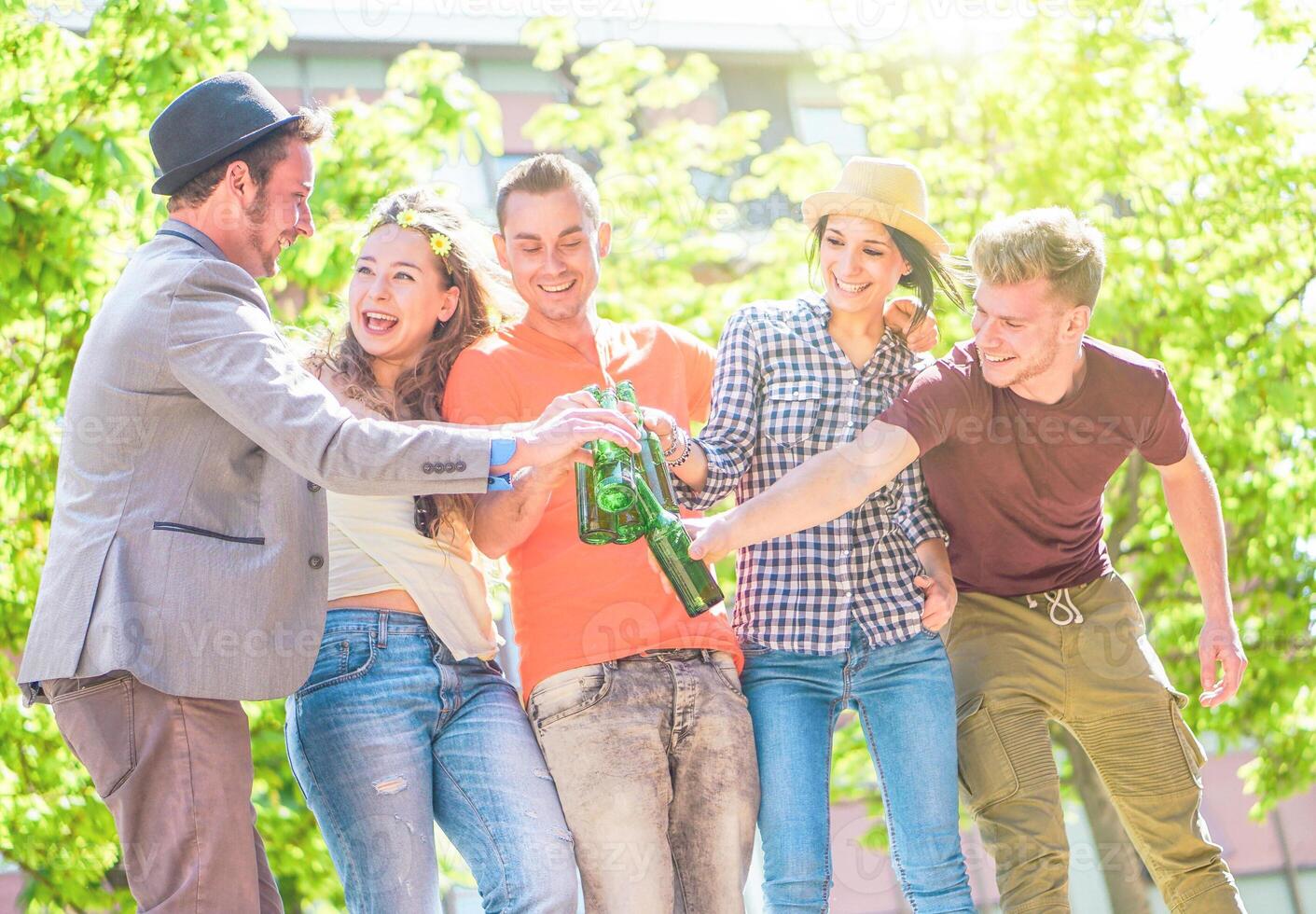 grupo do amigos desfrutando cervejas ao ar livre - feliz jovem pessoas tendo Diversão juntos brindar garrafas do Cerveja dentro a cidade - juventude amizade festa conceito - foco em esquerda homem braço foto