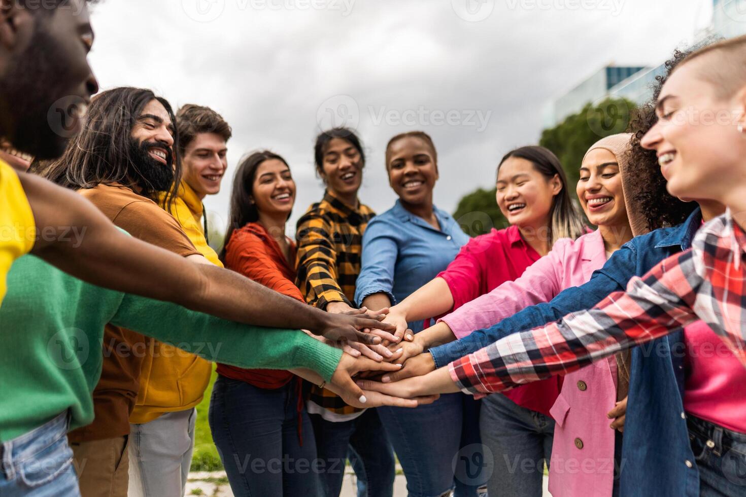 jovem multirracial comunidade do amigos tendo Diversão empilhamento mãos juntos ao ar livre - amizade e diversidade conceito foto