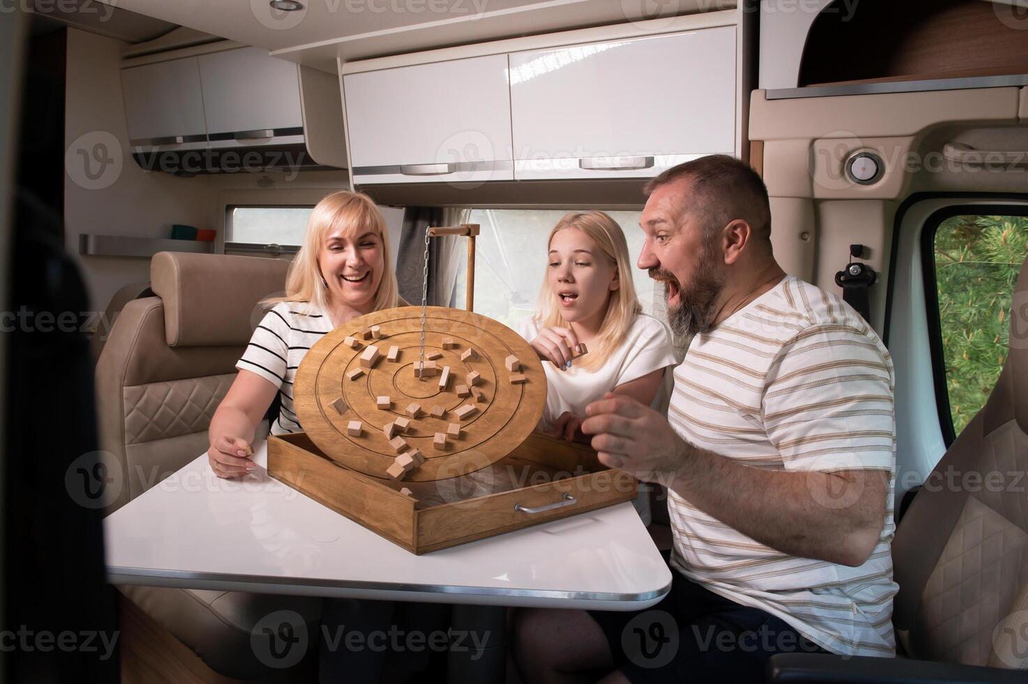 uma família do três é jogando uma borda jogos enquanto sentado dentro uma motorhome foto