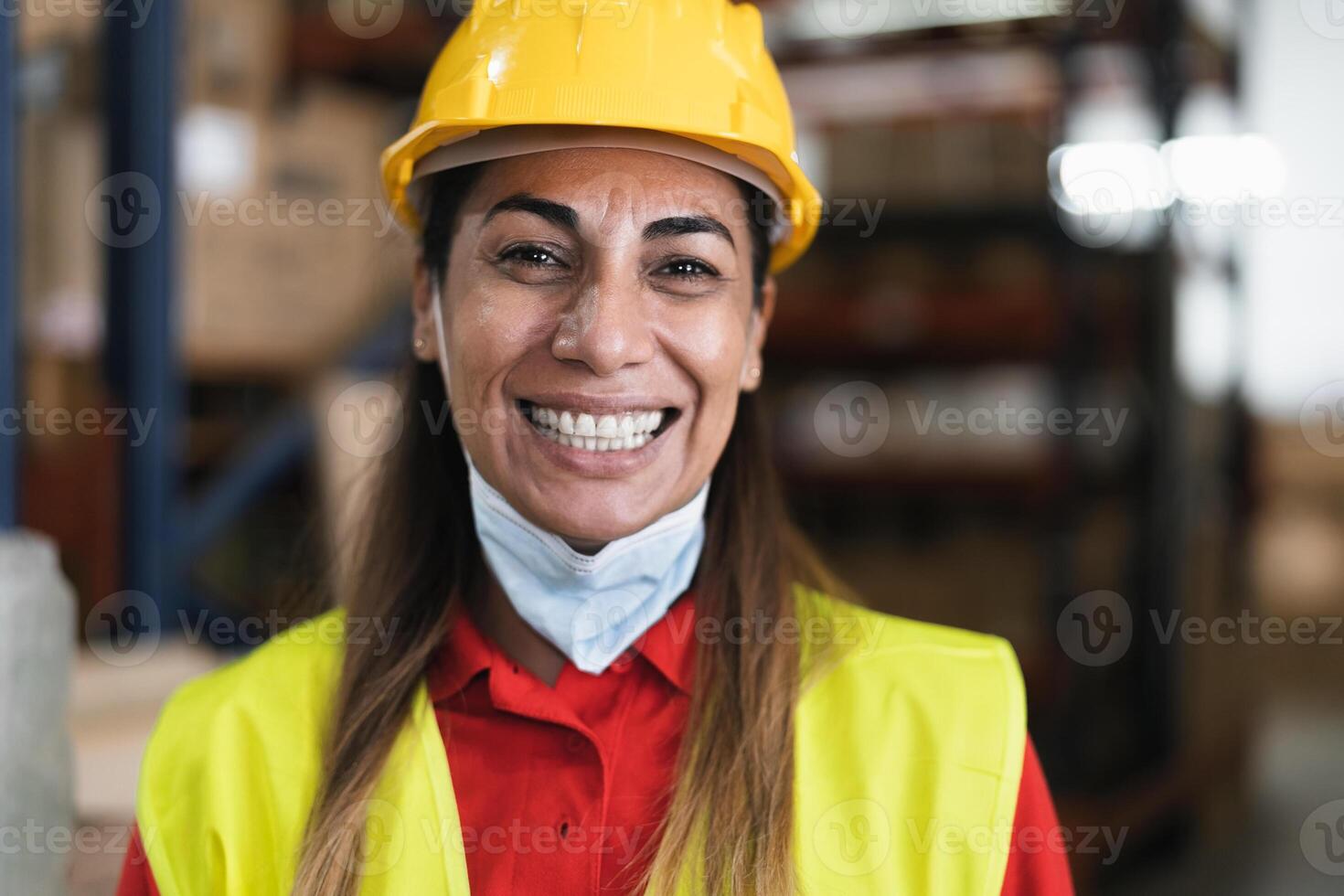 feliz latim mulher trabalhando dentro armazém enquanto vestindo face mascarar durante corona vírus pandemia - logístico e indústria conceito foto