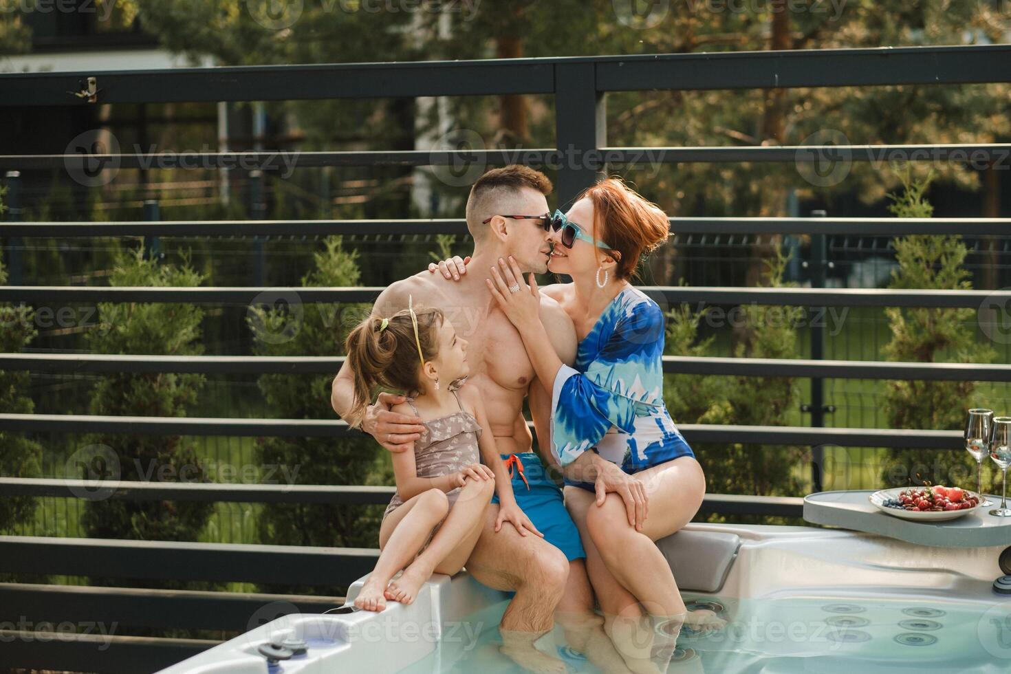 dentro verão, a família descansos dentro a ao ar livre quente banheira foto