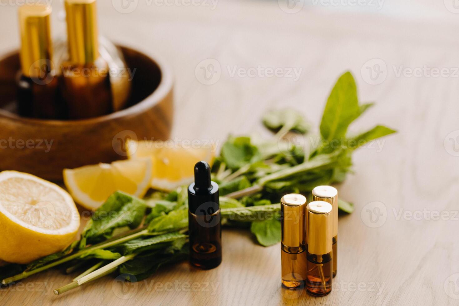 essencial óleo dentro garrafas com limão e hortelã fragrância deitado em uma de madeira superfície foto