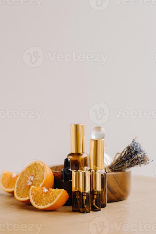 essencial óleo dentro garrafas com a aroma do laranja e lavanda deitado em uma de madeira superfície foto