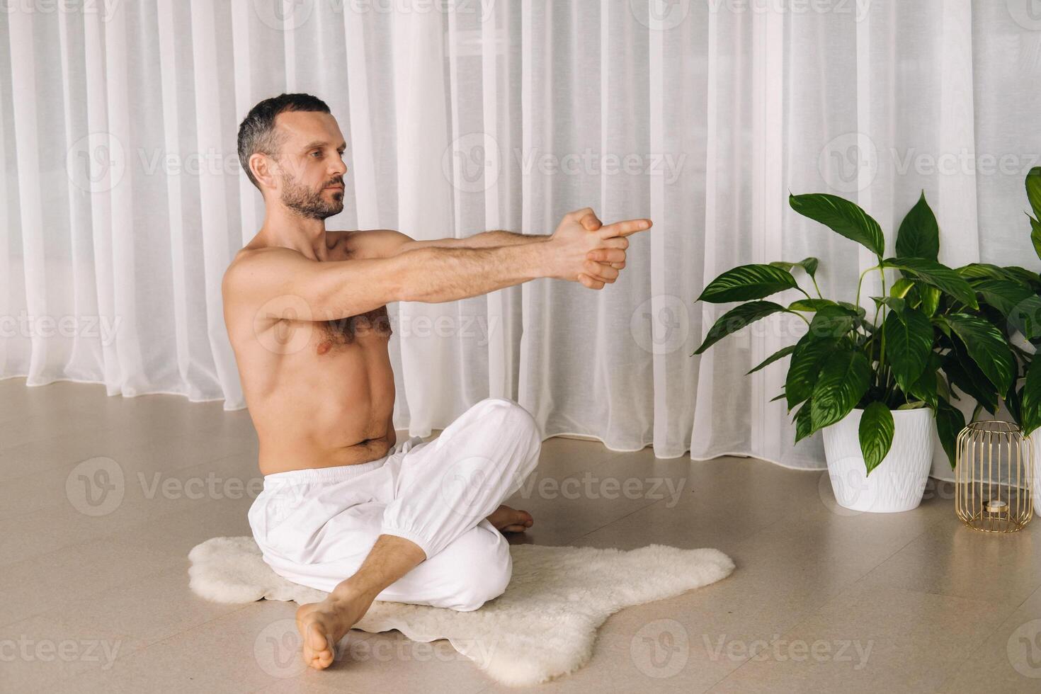 uma homem com uma nu tronco faz ioga dentro uma ginástica sala. a conceito do uma saudável estilo de vida foto