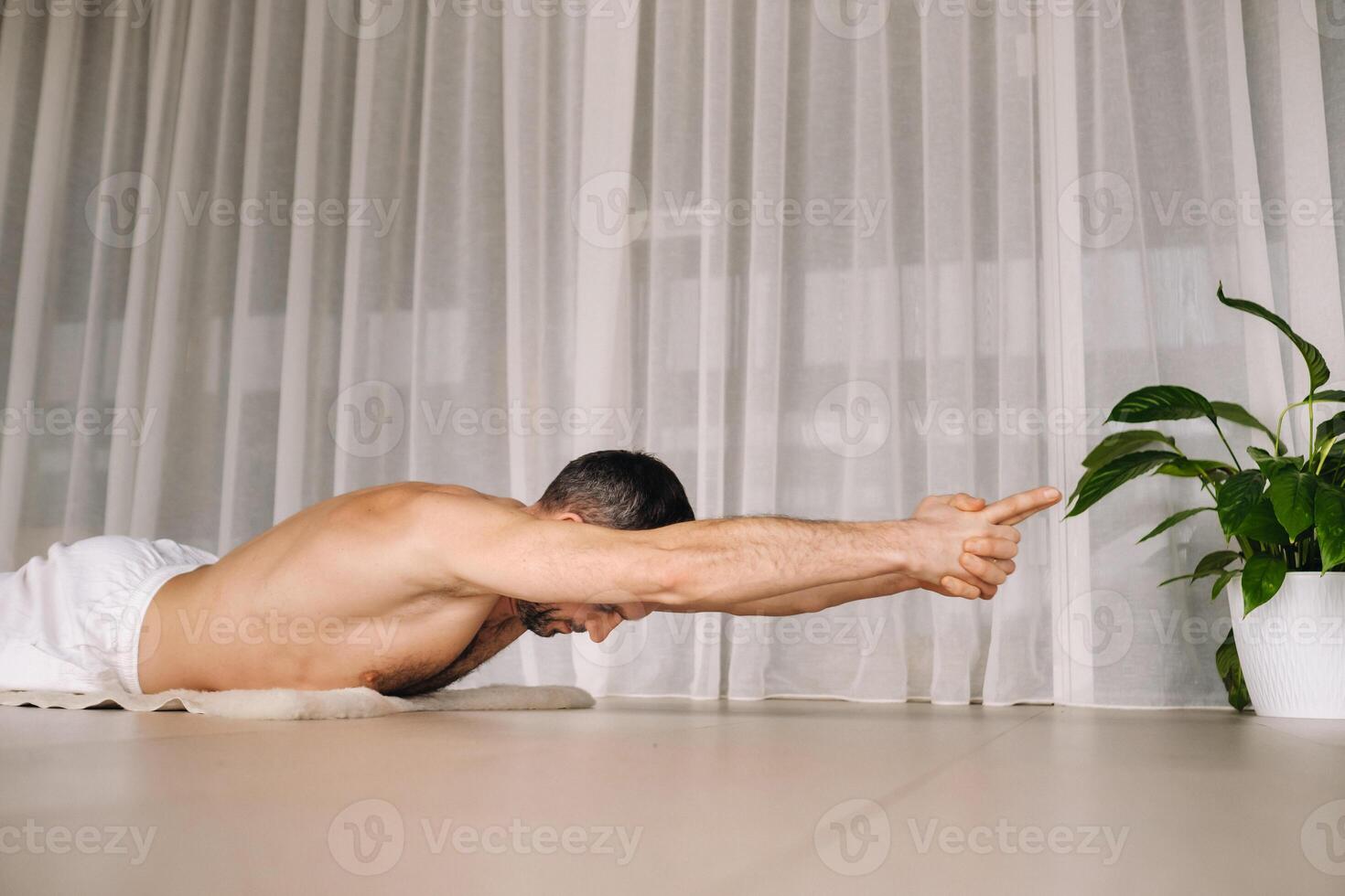 uma homem com uma nu tronco faz ioga dentro uma ginástica sala. a conceito do uma saudável estilo de vida foto