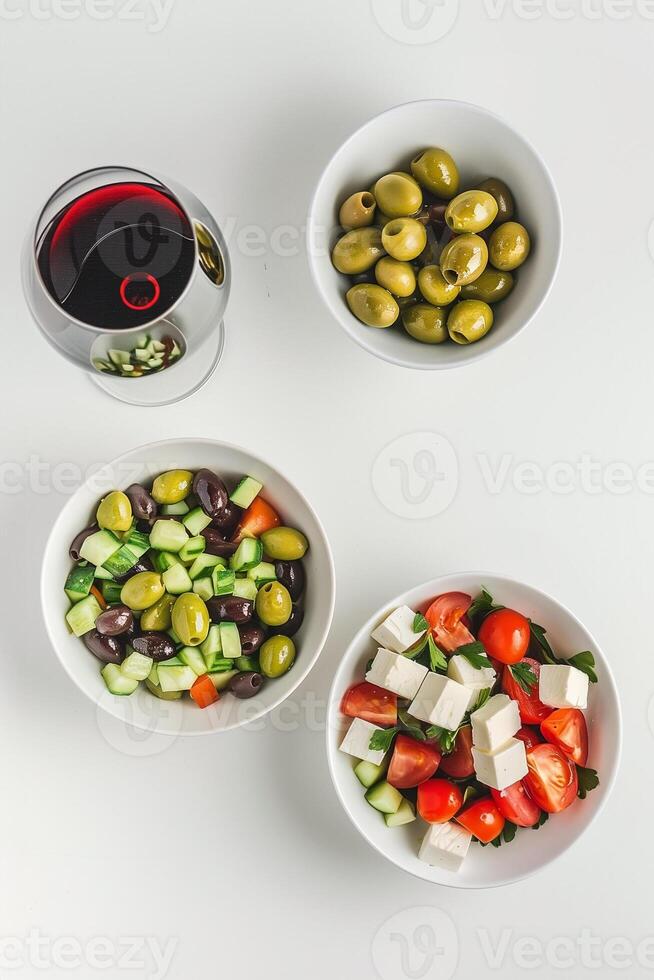 ai gerado Mediterrâneo cozinha conceito com a sobrecarga Visão do grego salada, misturado azeitonas, e vermelho vinho vidro em uma branco fundo foto
