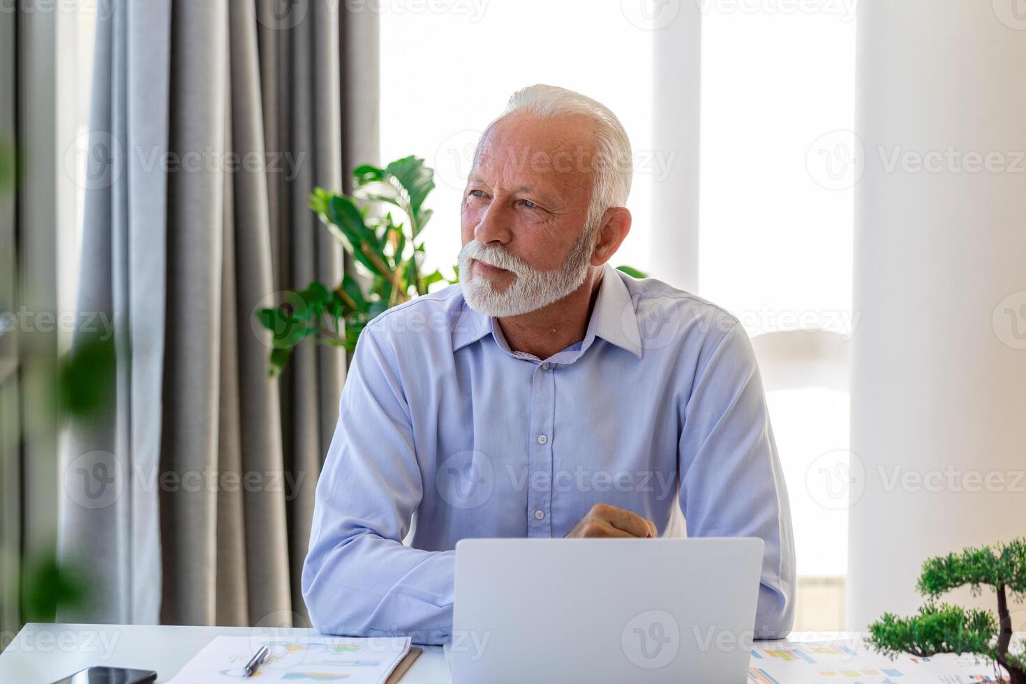 financeiro orientador homem de negocios usando dele computador portátil e fazendo alguns papelada enquanto sentado às escrivaninha e trabalhando. foto