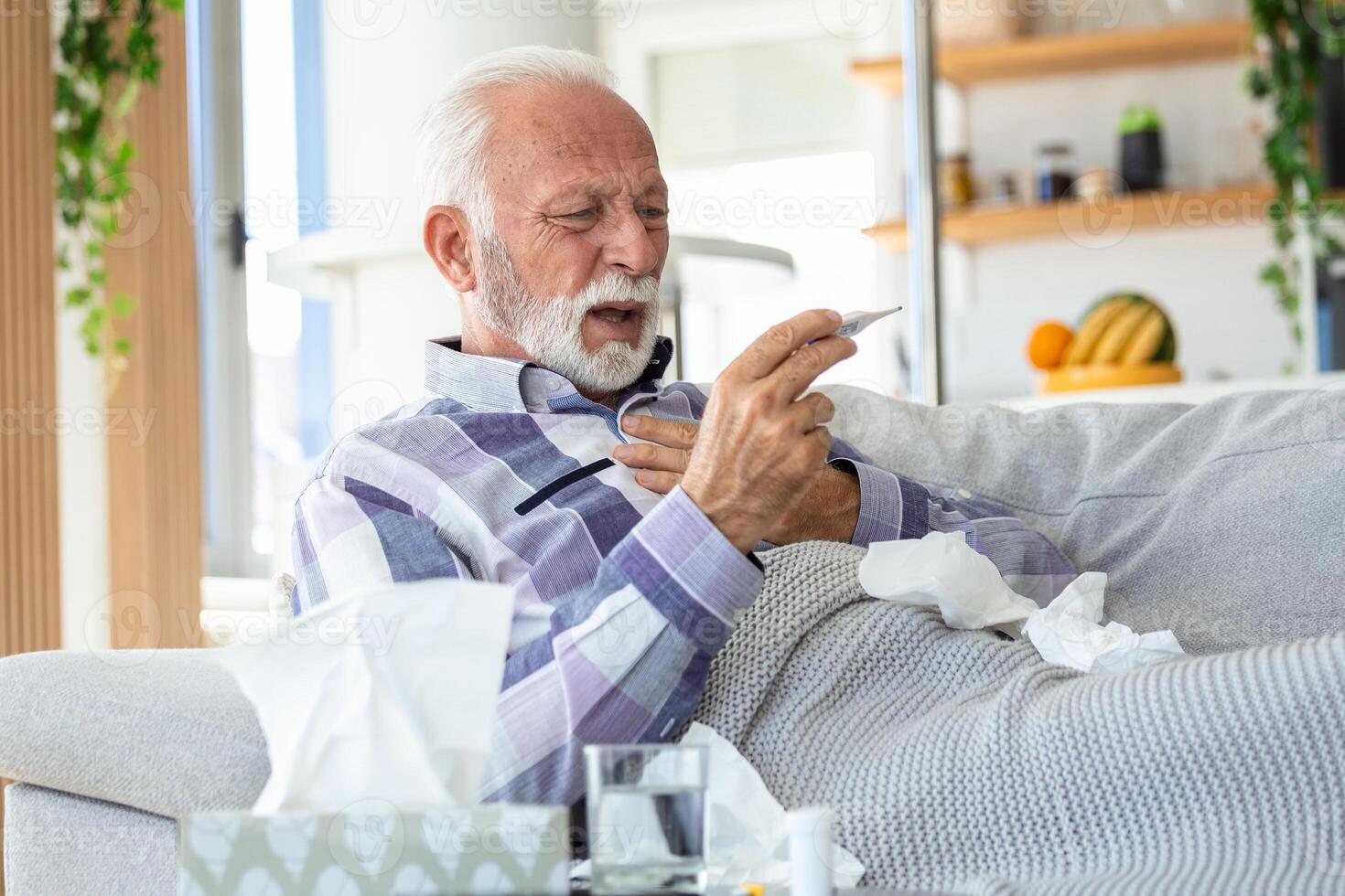 doente idosos homem verificação dele temperatura sofrimento a partir de sazonal gripe ou frio deitado em sofá pegando sofrimento a partir de sazonal gripe ou frio. . eu vou Senior sentir pouco saudável com gripe às casa foto