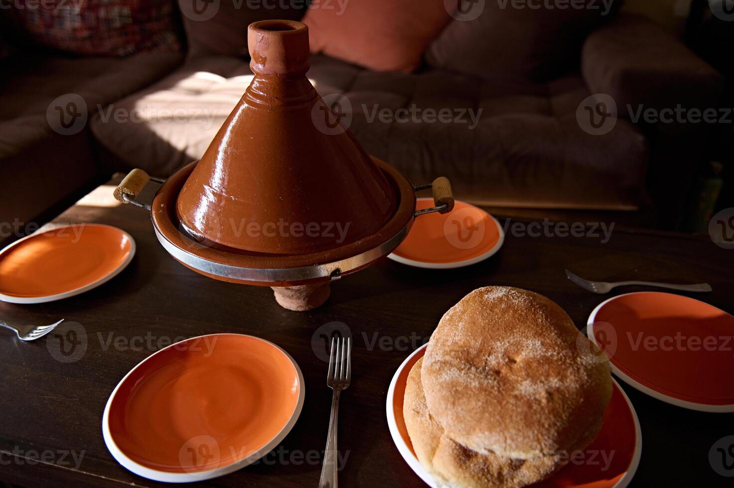 tradicional marroquino saboroso refeição cozinhou dentro tagine argila Panela com recentemente cozido pão em a mesa às casa foto