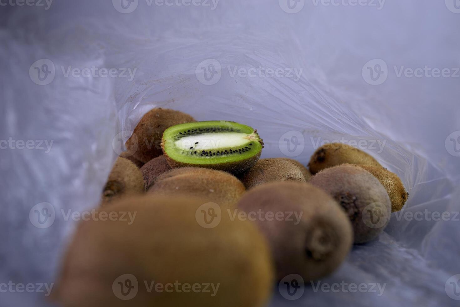 reutilizável branco malha compras saco com fruta, kiwi branco acinzentado mármore fundo. zero desperdício conceito, não plástico e seguro a planeta conceito foto