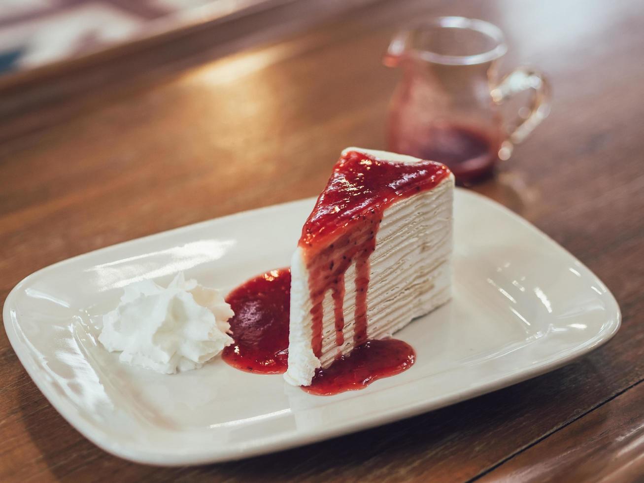 Bolo de crepe francês com molho de morango suculento. foto