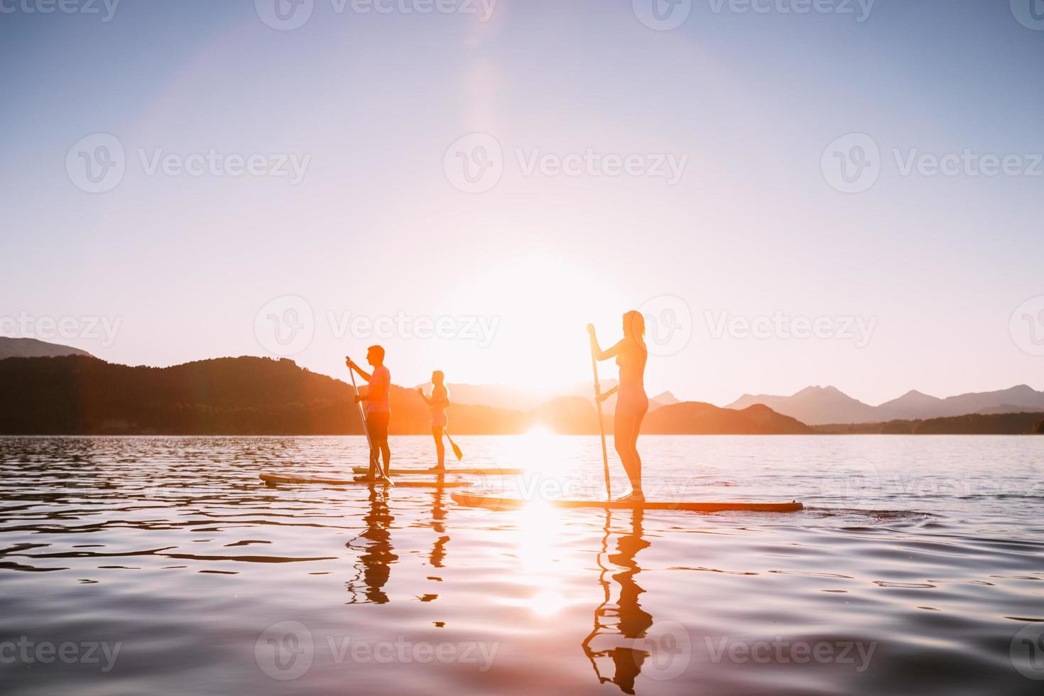 stand up paddle ao pôr do sol foto