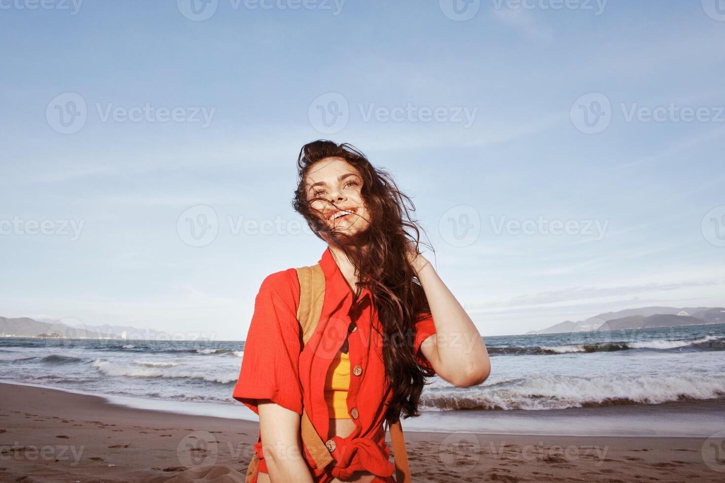 Beijado pelo sol, ensolarado liberdade. uma alegre mulher abraçando vida de a azul mar foto