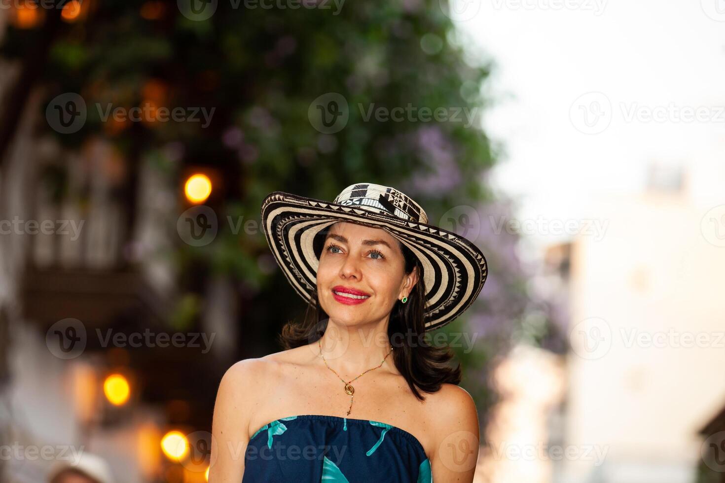 lindo mulher vestindo a tradicional colombiano chapéu chamado sombrero vueltiao às a histórico ruas do a cartagena de índias murado cidade foto