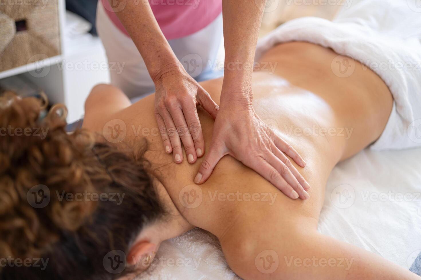 massagista fazendo massagem para mulher dentro salão foto