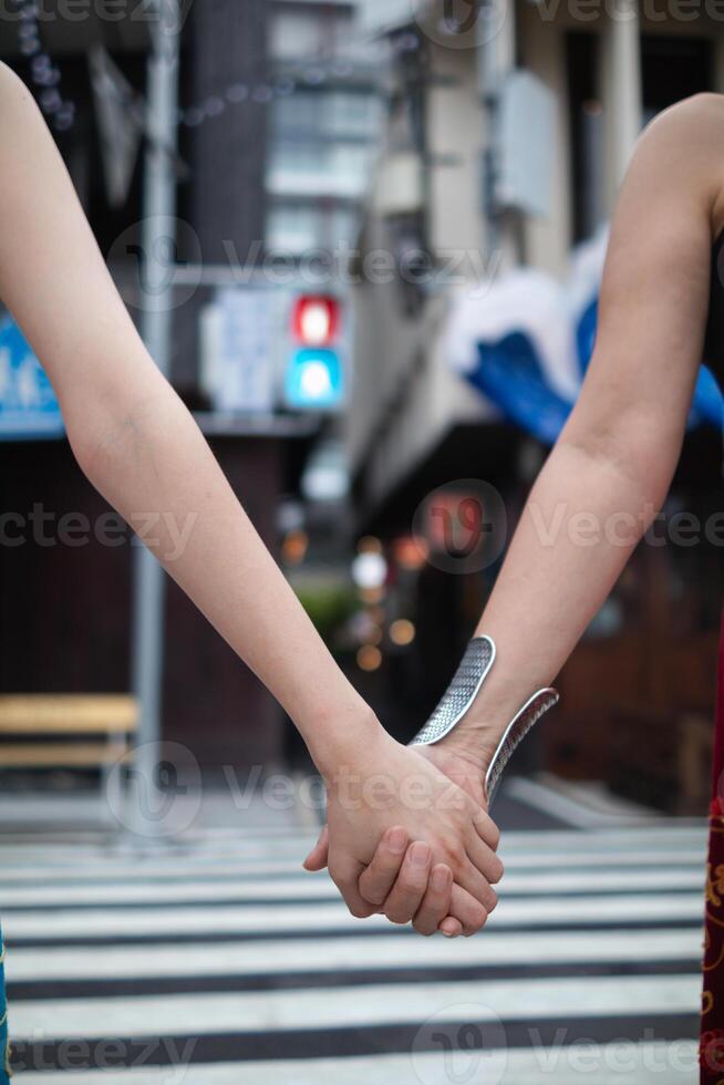 lgbtq casais abertamente andar mão dentro mão baixa rua para mostrar lgbtq direitos e liberdades do amor para cada outro. lgbtq casais andar mão dentro mão baixa rua mostrar seus amor e amizade para cada de outros foto