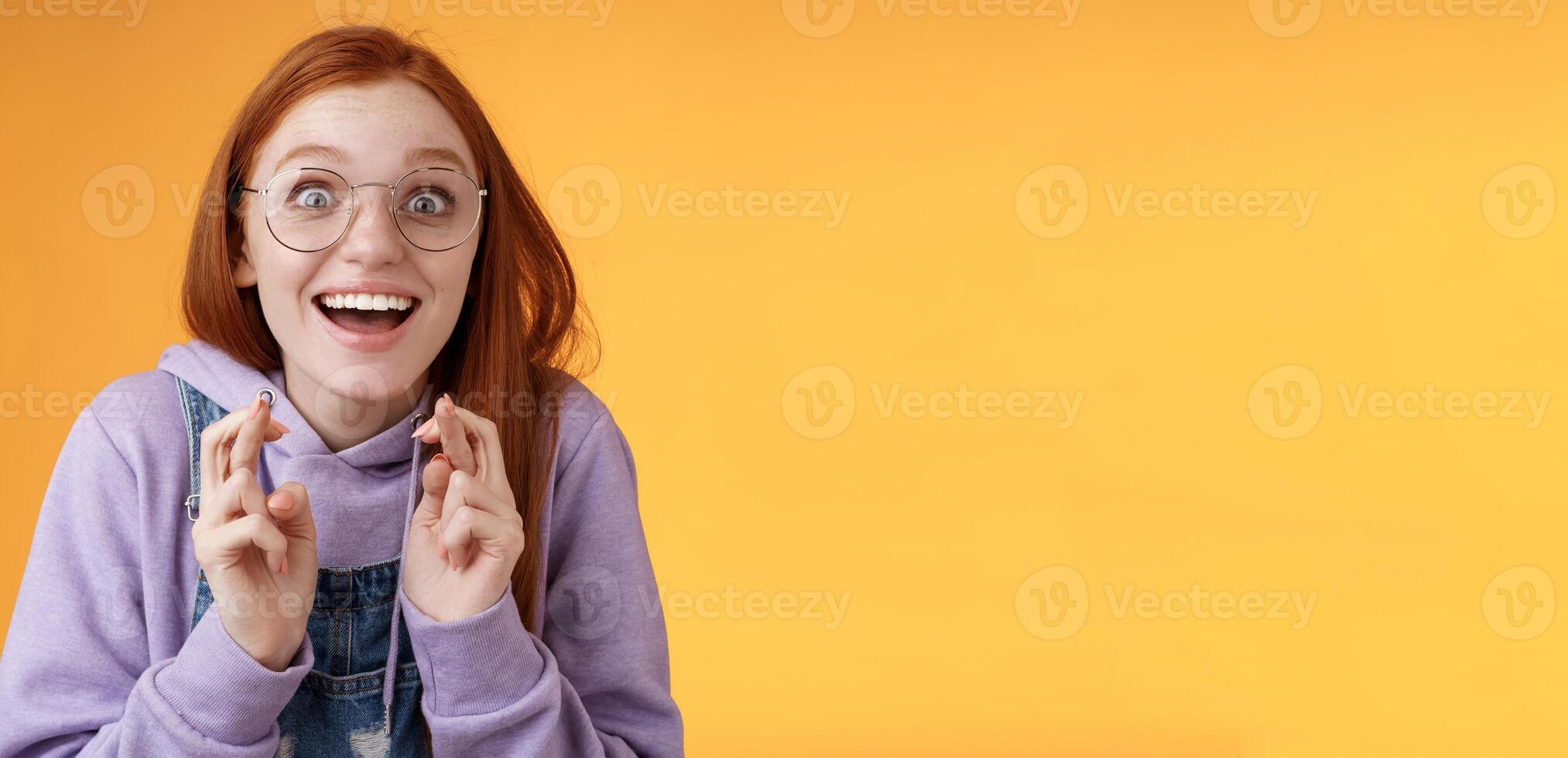 surpreso menina Sonhe veio verdade a comemorar em pé divertido animado Cruz dedos Boa sorte desejo realizada sorridente emotivo emocionados finalmente ganhar receber Boa notícia otimista esperançoso laranja fundo foto