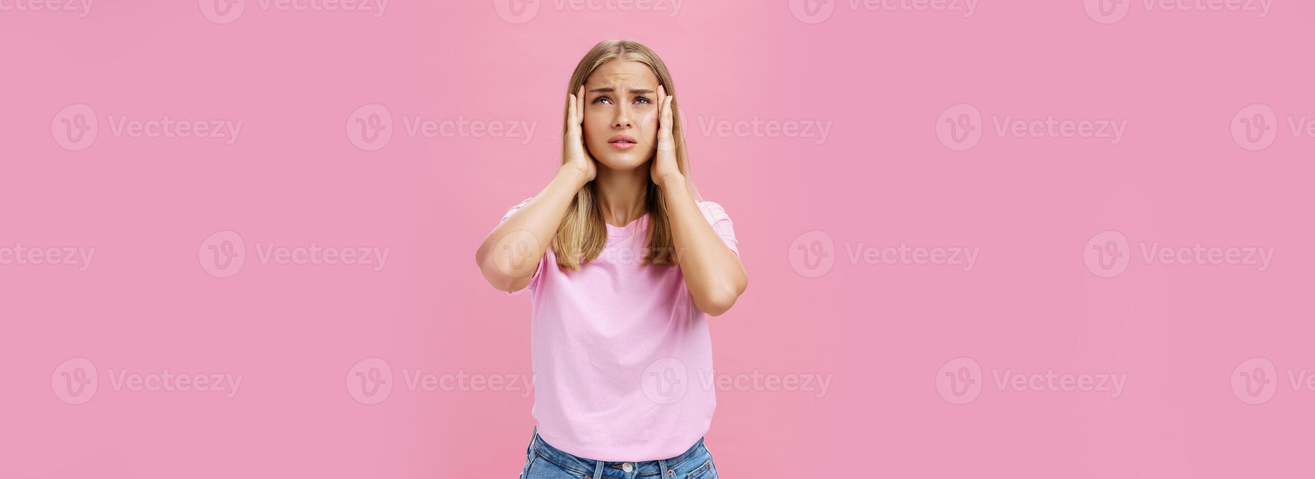 mulher tentando lembrar importante número tocante templos com mãos olhando acima preocupado e focado tendo problema para lembrar em formação em pé intenso contra Rosa fundo foto