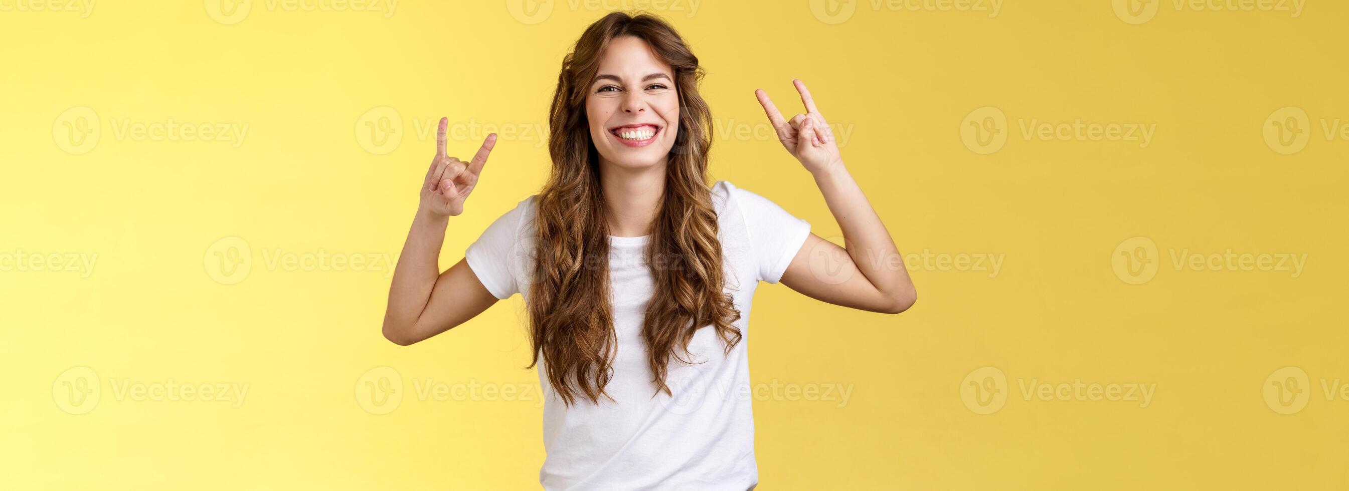 entusiasmado carismático por sorte menina tendo Diversão apreciar impressionante música mostrar rock-n-roll gesto sorrindo emocionados gostar metal pesado dançando otimista positivo em pé entretido amarelo fundo foto