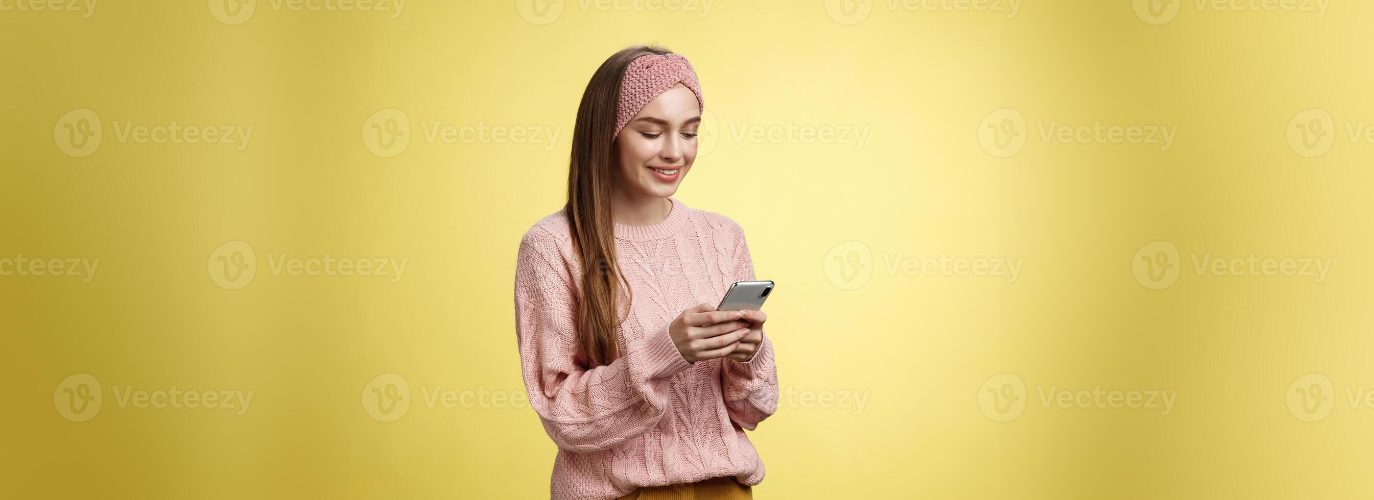 menina conversando, mensagens de texto, enviando engraçado emoji amigo sorridente entretido segurando Smartphone olhando dispositivo tela divertido, desfrutando jogando com impressionante aplicativo, assistindo vídeo conectados através da celular foto