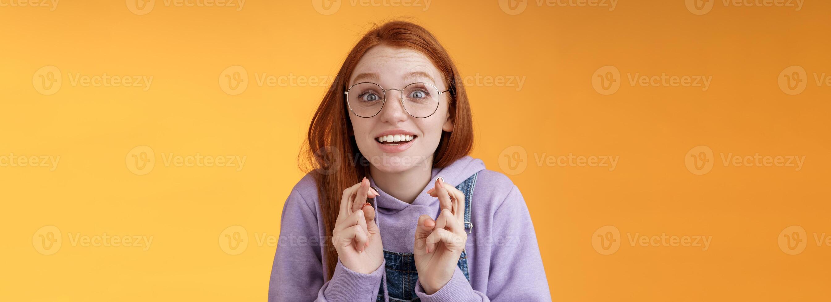 menina animado assistindo resultados Cruz dedos Boa sorte torcendo favorito equipe quer ganhar Sonhe venha verdade emocionados aberto boca Largo olhar fixamente Câmera esperançoso suplicante desejo realizada, laranja fundo foto