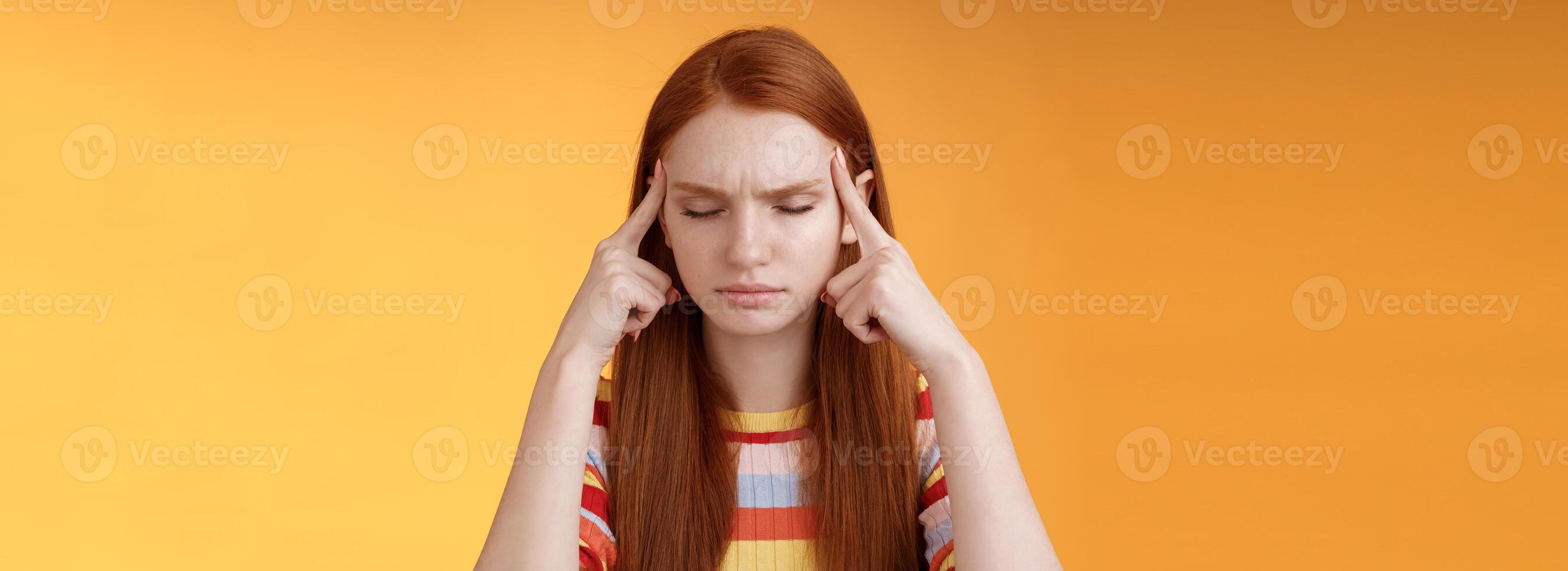 menina obtendo pensamentos empilhado tentando pensar stright concentrando concentrando importante tarefa lembrar número toque templos fechar olhos Veja a sério em pé intrigado Sofra dor de cabeça, laranja fundo foto