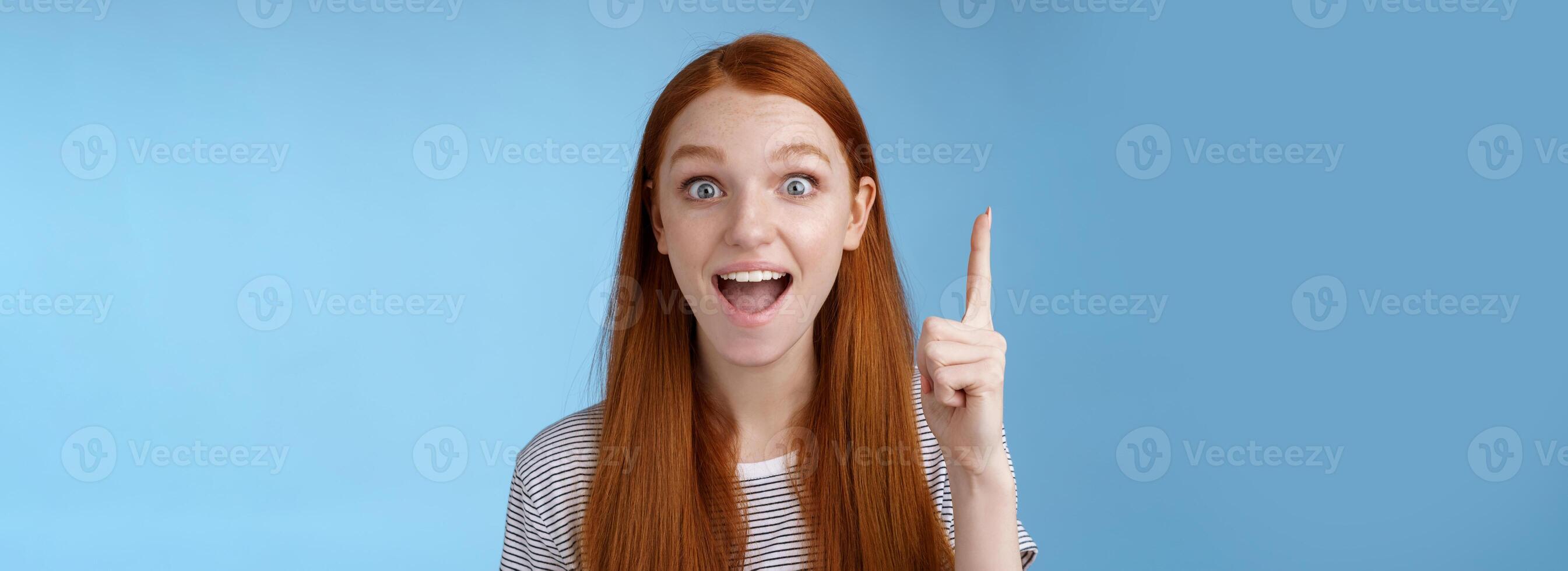 animado boa aparência alegre gengibre namorada adicionar idéia conversação levantar índice dedo eureka gesto aberto boca Largo contar sugestão sorridente amplamente ponderando excelente variante, azul fundo foto