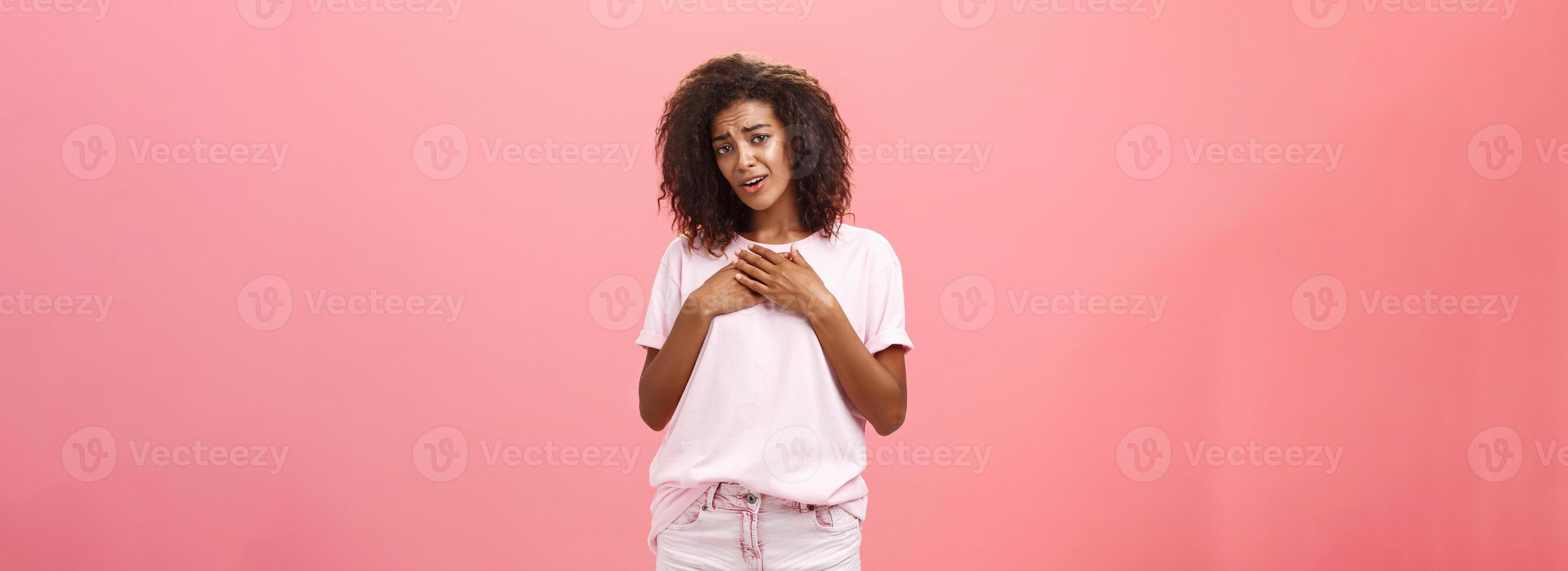 oh você fundição meu coração tão doce. tocou e grato boa aparência Encantado africano americano mulher com encaracolado cabelo dentro à moda equipamento segurando Palmeiras em coração suspirando a partir de deleite e grato sentimentos foto