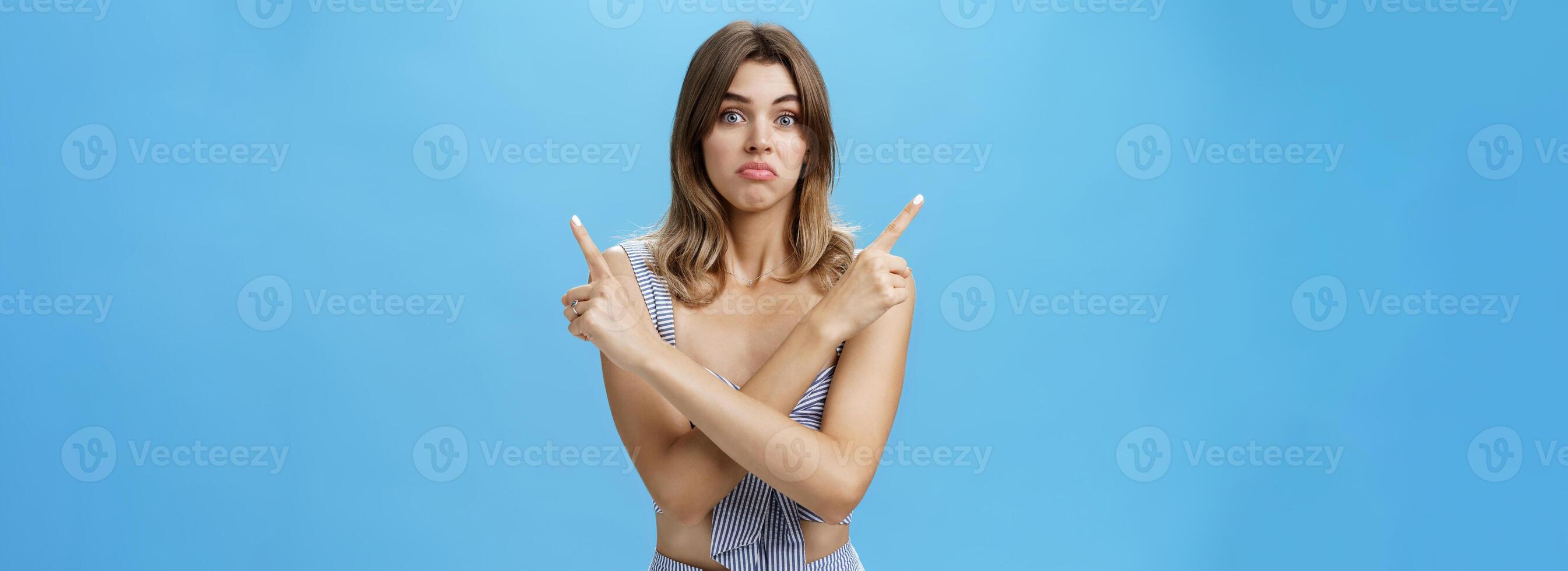 Socorro menina faço Difícil decisão. retrato do sombrio inseguro hesitante fofa fêmea modelo com natural cabelo e bronzeado cruzando mãos sobre corpo apontando às superior certo e esquerda cantos com triste incerto Veja foto