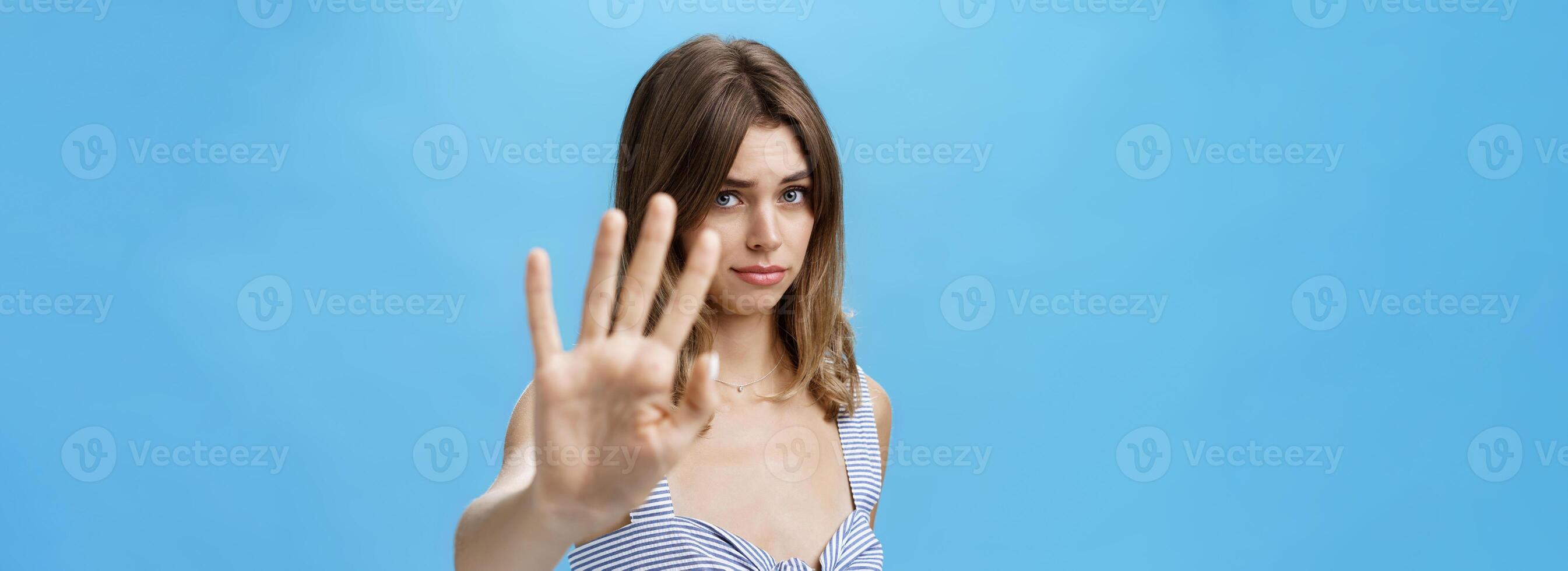 boba e tímido inseguro atraente menina puxar mão para para cobrir face a partir de Câmera fazer temperamental tímido expressão Perguntando para Pare não gosto o que acontecendo dizendo não com corpo língua sobre azul parede foto