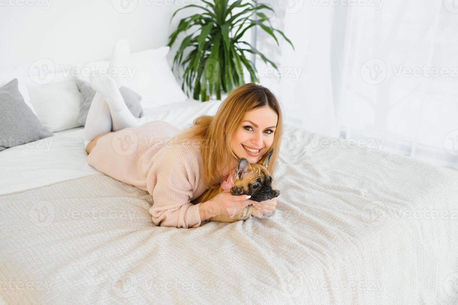 jovem mulher jogando com dela cachorro às casa foto
