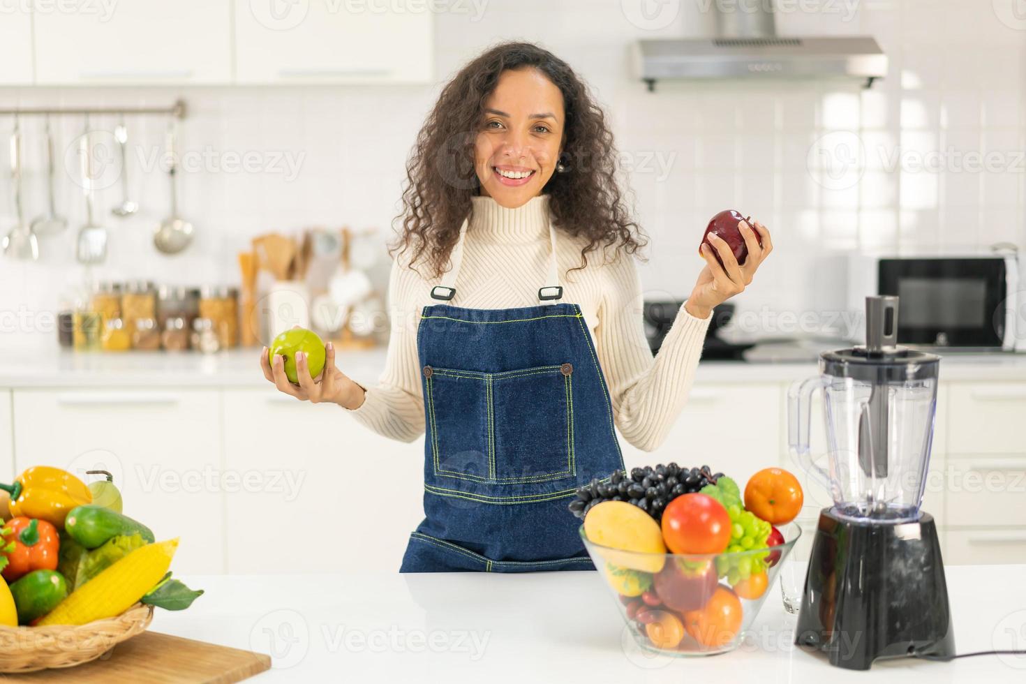 mulher latina fazendo suco na cozinha foto