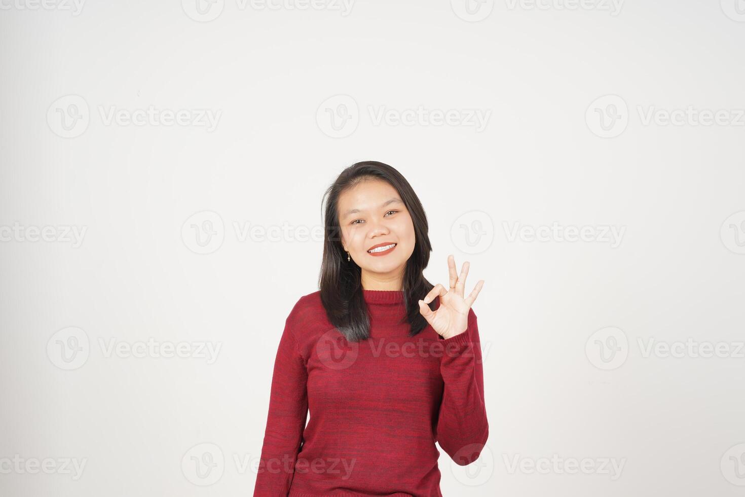 jovem ásia mulher dentro vermelho camiseta sorridente e mostrando OK placa isolado em branco fundo foto